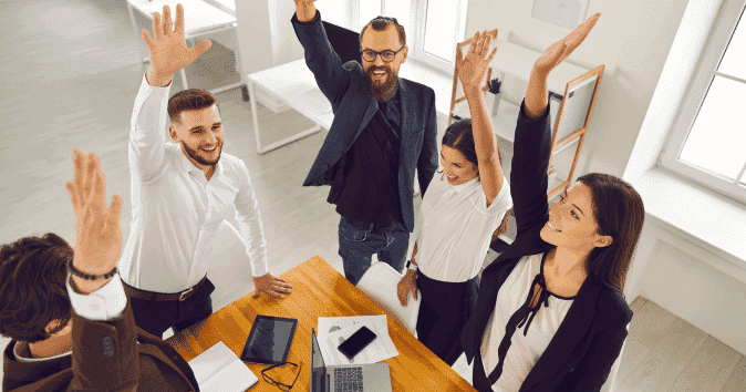 team-raising-arms-after-team-building-session.png