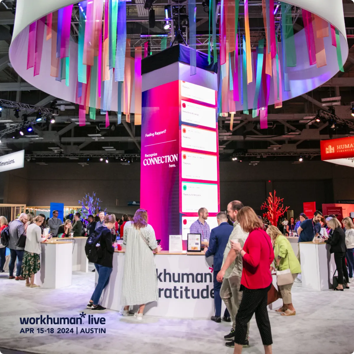 A vibrant scene from Workhuman Live 2024 featuring attendees walking through a well-lit conference area.